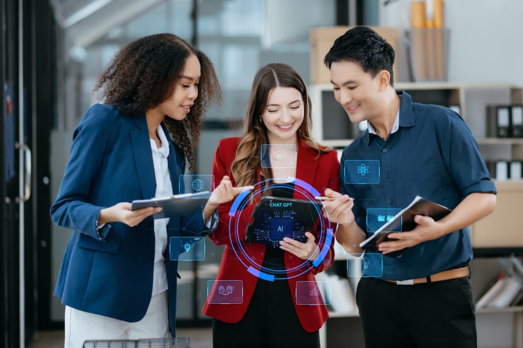 multifamily ai tools Three people in business attire collaborate using digital tablets, with holographic AI interface graphics displayed in the foreground. mpro Digital Edge