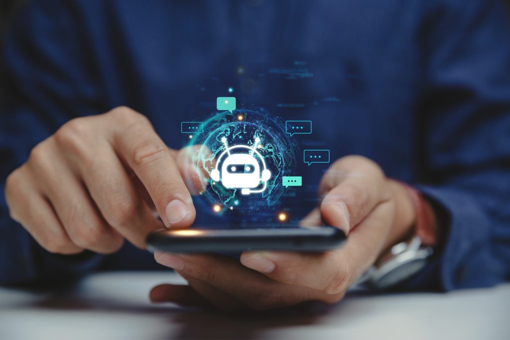 multifamily ai tools Person using a smartphone with a digital chatbot icon and chat bubbles hovering above the screen. mpro Digital Edge